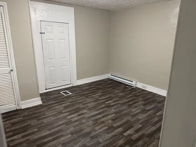 an empty room with wooden floor and closet