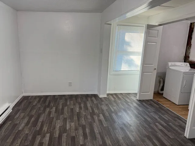 an empty room with wooden floor and a window