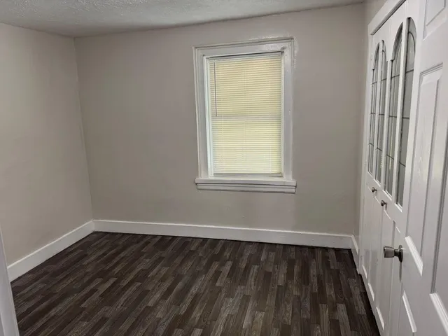 a view of a room with wooden floor and a window