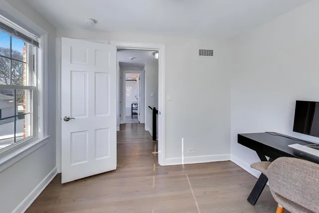 a view of a workspace with furniture and a window