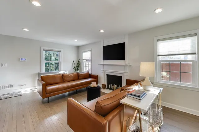 a living room with furniture a fireplace and a flat screen tv