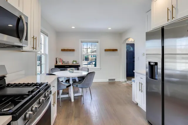 a kitchen with stainless steel appliances granite countertop a stove a refrigerator and a dining table