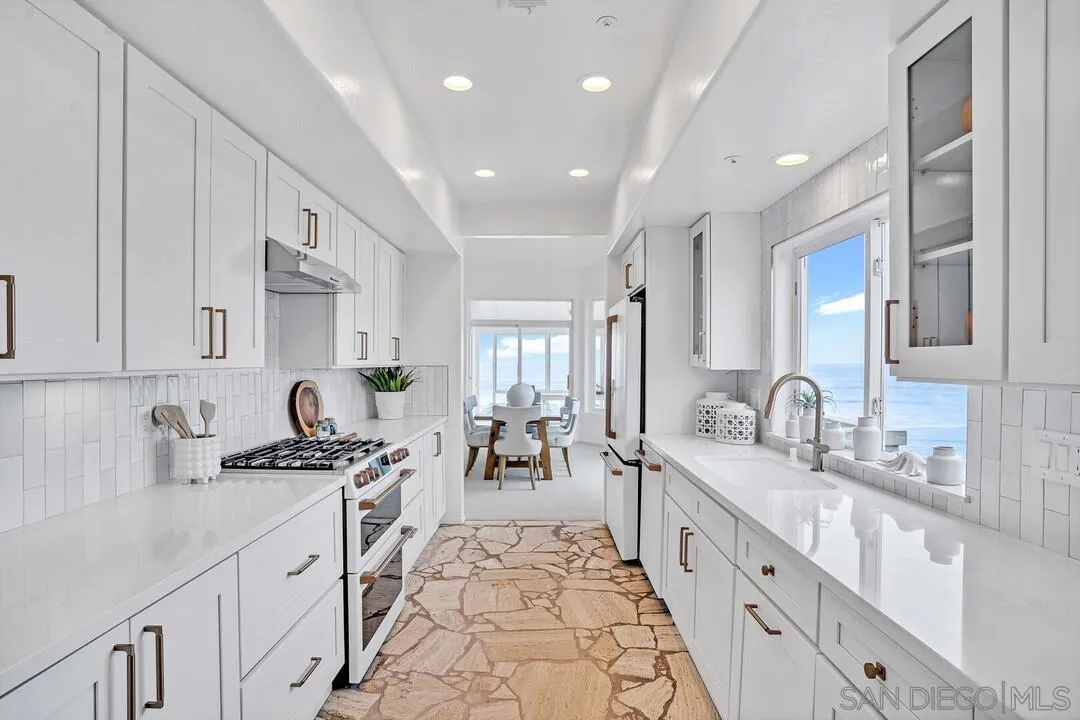 1206 Seacoast Drive, Unit C Imperial Beach, CA 91932 - Photo 5 of 32 a large white kitchen with stainless steel appliances lots of counter space and a sink