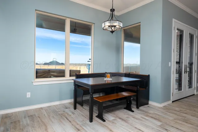 a kitchen with granite countertop a table chairs microwave and cabinets