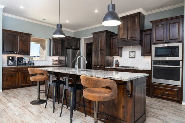 a kitchen with granite countertop a sink and cabinets