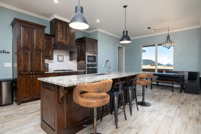 a kitchen with stainless steel appliances granite countertop wooden cabinets a refrigerator and a sink