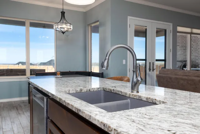 a kitchen with stainless steel appliances granite countertop a refrigerator a sink dishwasher a stove with wooden cabinets and floor