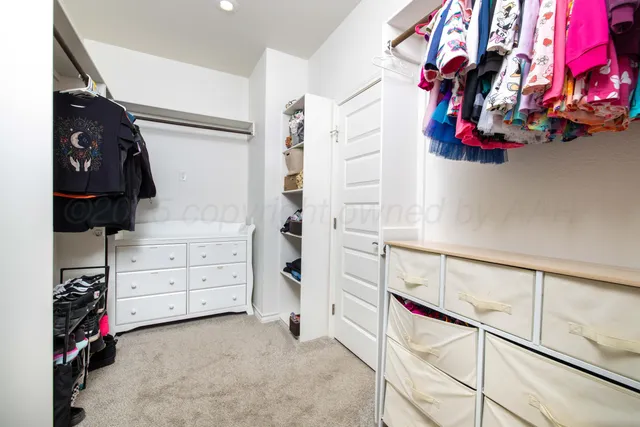 a view of walk in closet with clothes and shoes