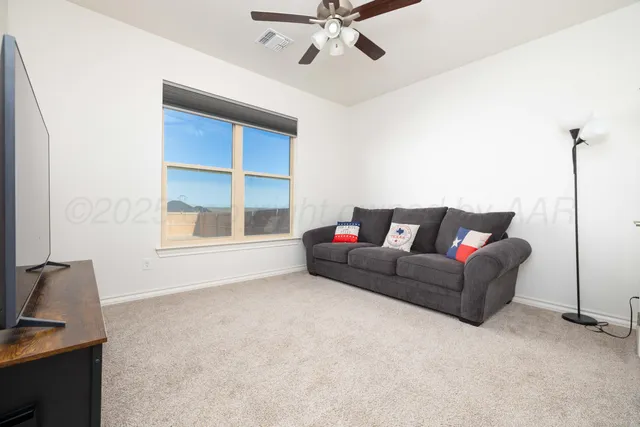 a living room with furniture a window and a flat screen tv