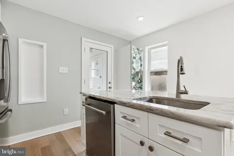 a kitchen with granite countertop white cabinets and a sink