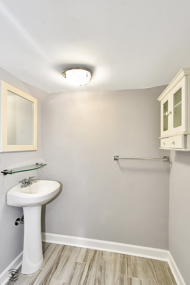 1712 Laurel Drive Mount Prospect, IL 60056 - Photo 22 of 26 a bathroom with a sink a mirror and a toilet