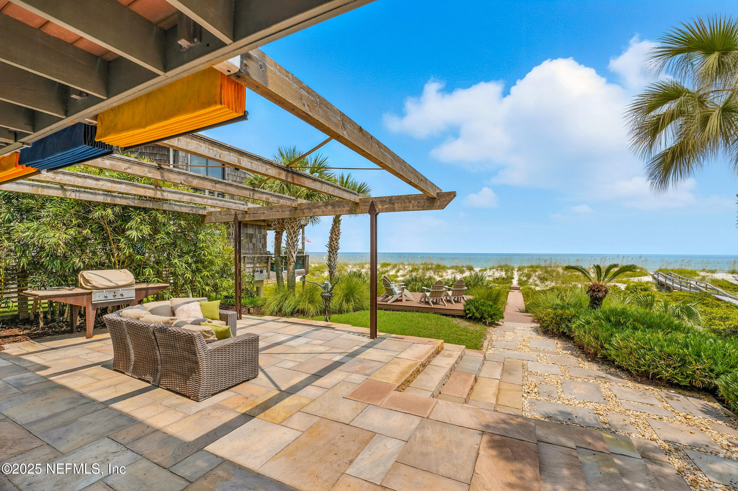1789 Beach Avenue Atlantic Beach, FL 32233 - Photo 41 of 55 a view of a patio with couches and table and chairs under an umbrella