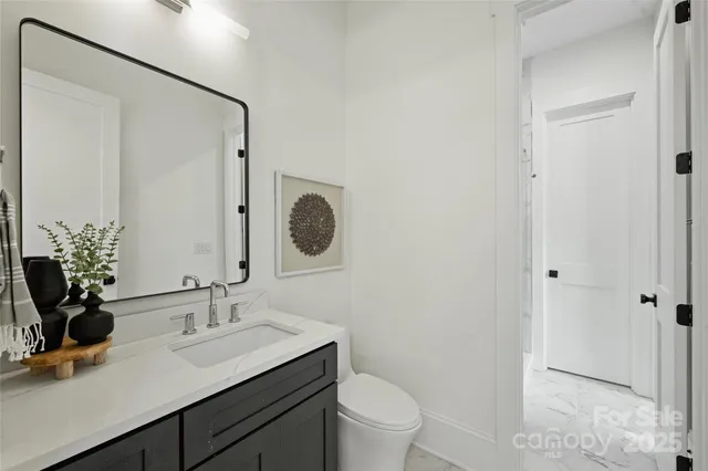 a bathroom with a granite countertop sink a toilet and a mirror