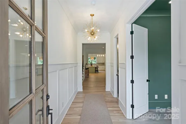 a view of a hallway view with wooden floor and a living room