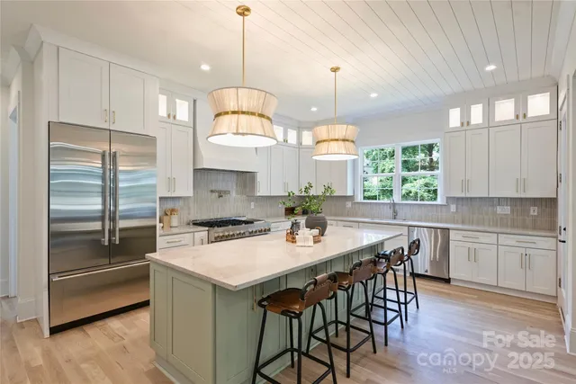 a kitchen with kitchen island a large counter top space appliances and a center island