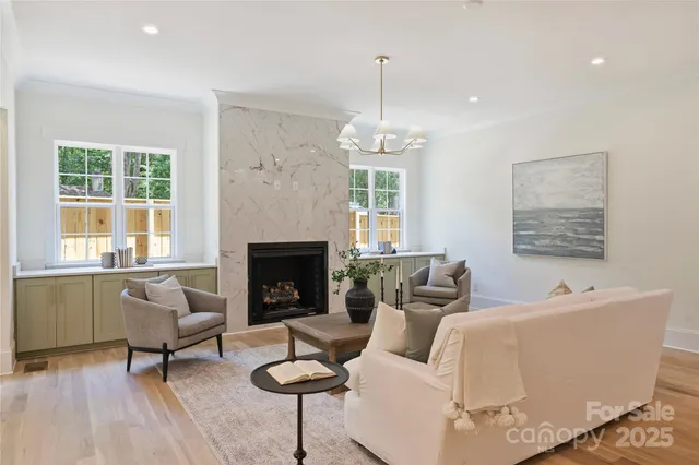 a living room with furniture a fireplace and a large window