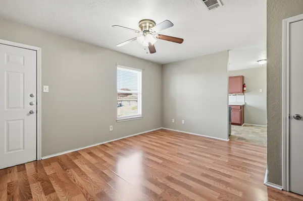 a view of empty room with wooden floor