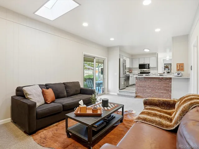 a living room with furniture and kitchen view