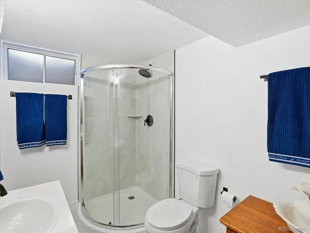 a bathroom with a toilet a sink and shower