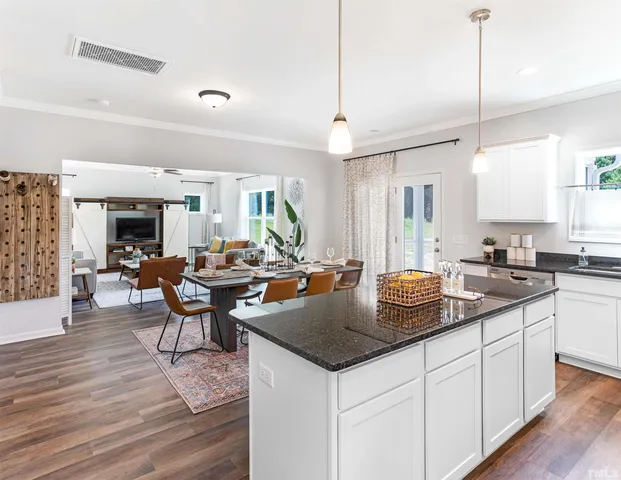 a kitchen with stainless steel appliances kitchen island granite countertop a stove a sink and a refrigerator
