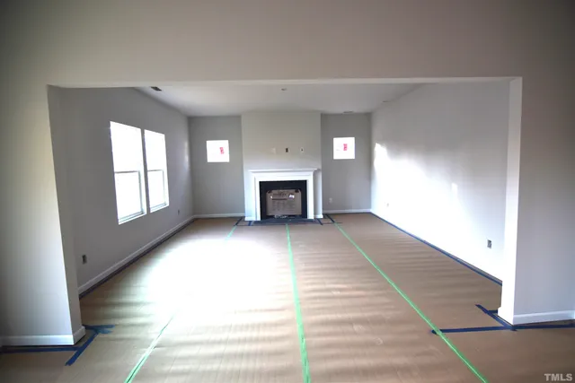 a view of an empty room with a fireplace and a window