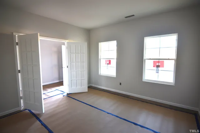 a view of an empty room with closet and entryway