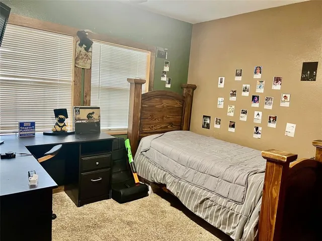 a bedroom with a bed and dresser with mirror