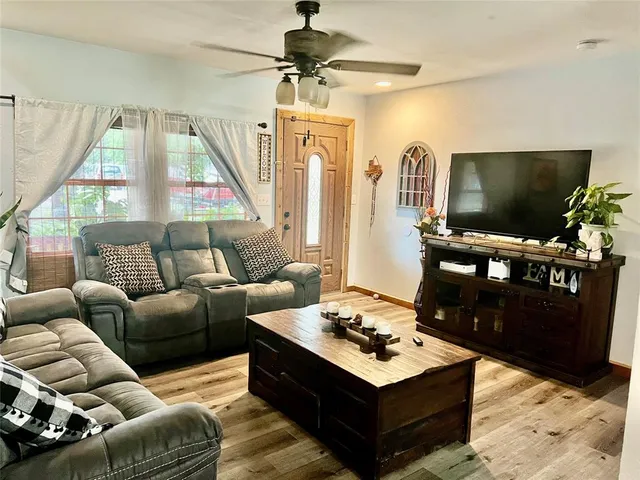 a living room with furniture a flat screen tv and a window