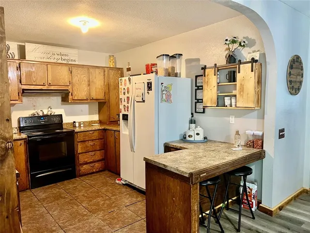 a kitchen with a refrigerator and a stove top oven