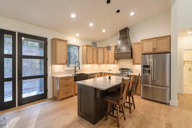 a kitchen with a table chairs refrigerator and cabinets