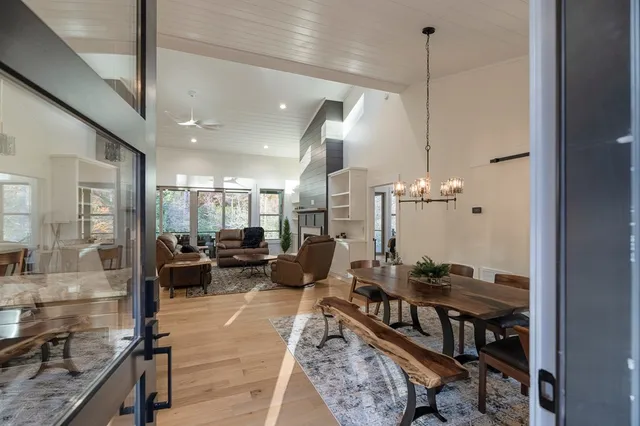 a living room with furniture a dining table and a chandelier