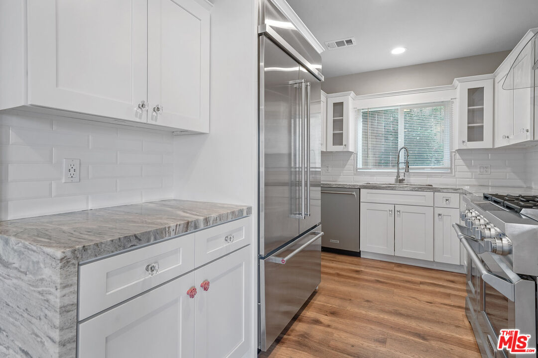 54 West Glenarm Street Pasadena, CA 91105 - Photo 7 of 18 a kitchen with a sink stove and cabinets