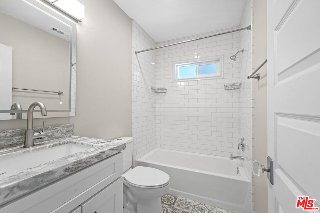 54 West Glenarm Street Pasadena, CA 91105 - Photo 9 of 18 a bathroom with a granite countertop sink a toilet and shower