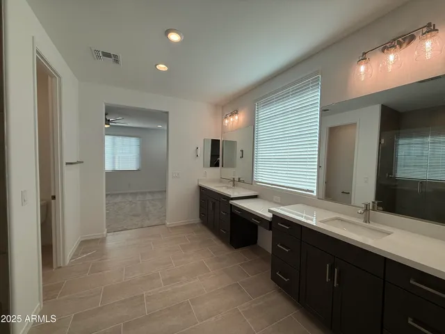 a large bathroom with a double vanity sink a mirror and a shower