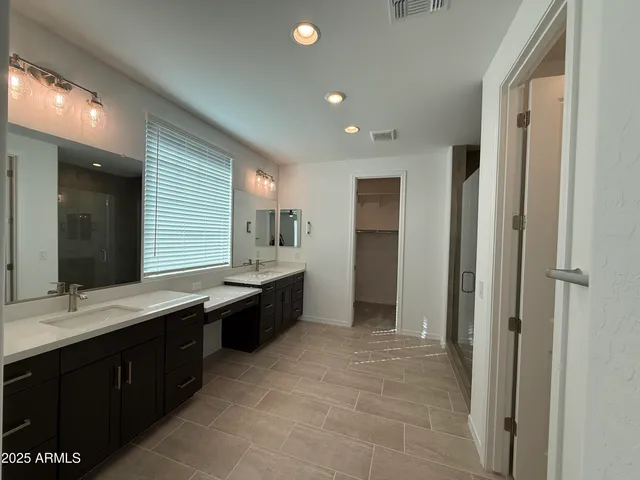 a large bathroom with a double vanity sink a mirror and a bathtub