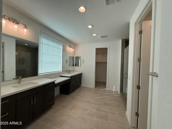 a large bathroom with a double vanity sink a mirror and a bathtub