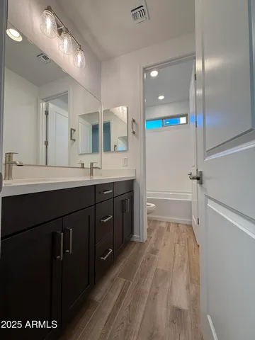 a spacious bathroom with a double vanity sink a mirror and a shower