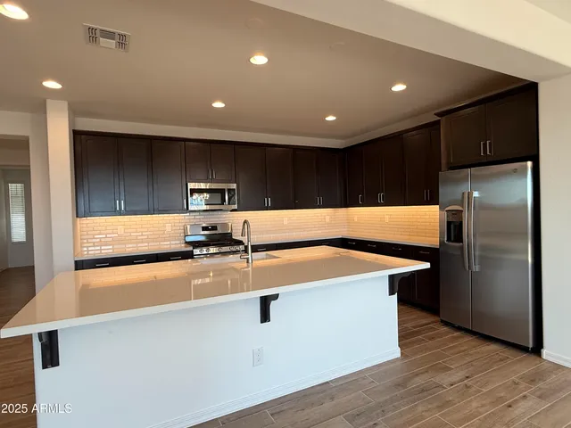 a kitchen with kitchen island a sink a stove and refrigerator