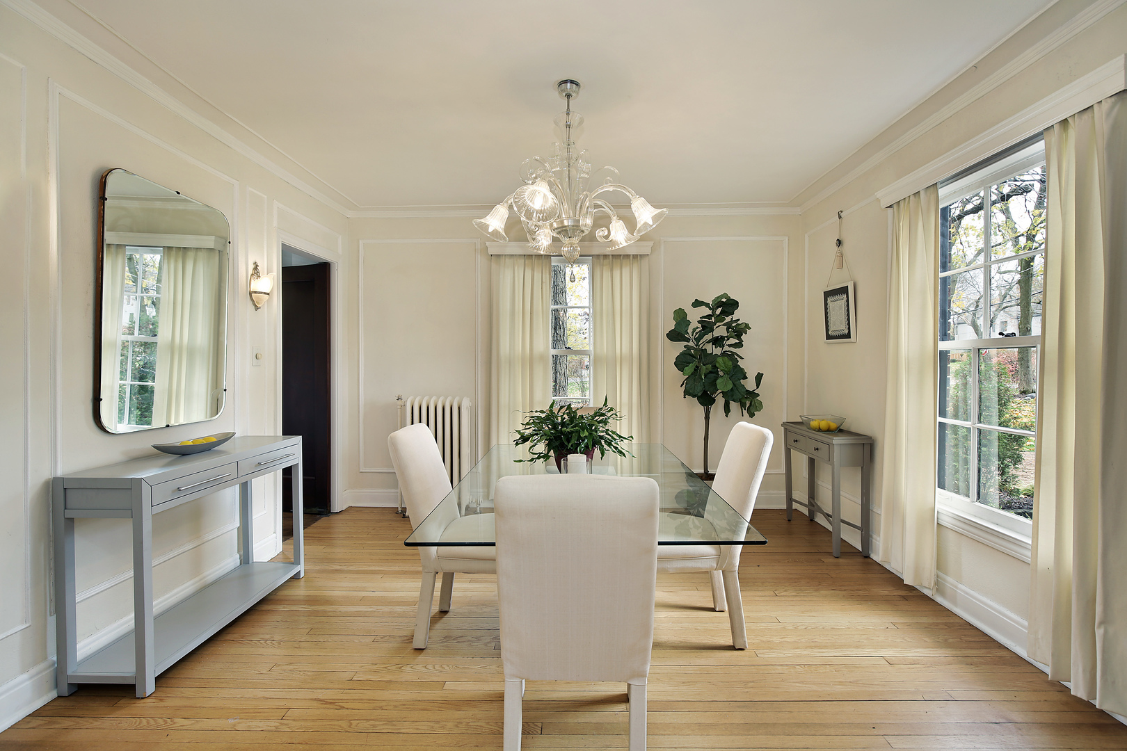 229 Sylvan Road Glencoe, IL 60022 - Photo 10 of 35 a dining room with wooden floor a chandelier a glass table and chairs