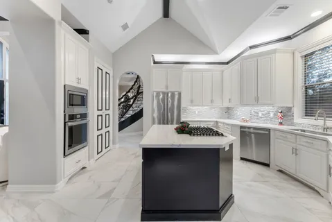 a kitchen with stainless steel appliances granite countertop a stove sink and cabinets