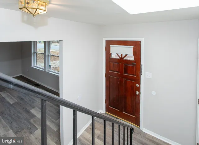 a view of a hallway with wooden floor and a window