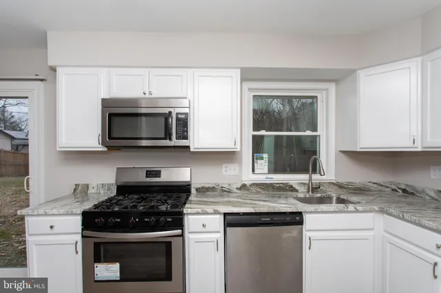 a kitchen with stainless steel appliances granite countertop a stove a microwave and a sink