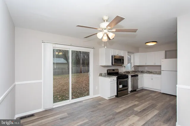 a view of a kitchen with a sink a refrigerator and a stove top oven