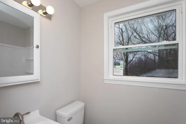a bathroom with a sink toilet and a mirror
