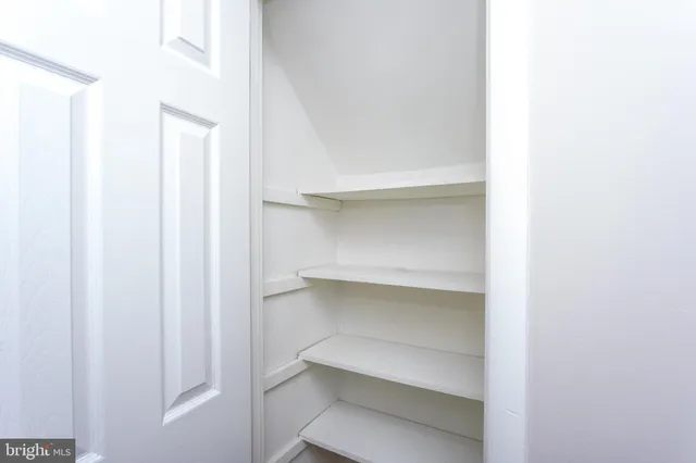 an empty room with a ceiling fan and window