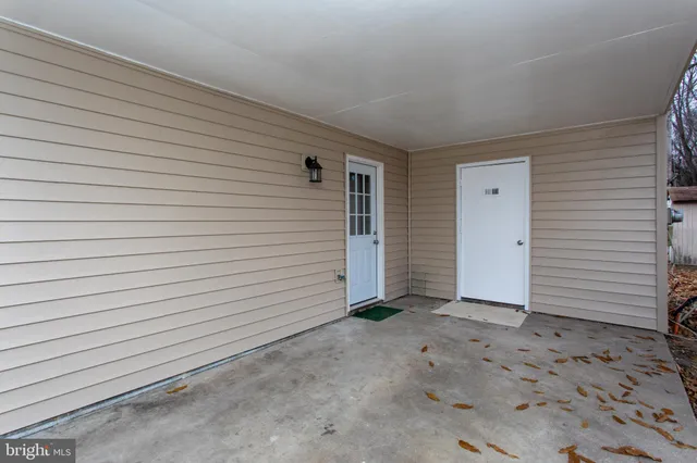 a front view of a house with a yard covered with snow