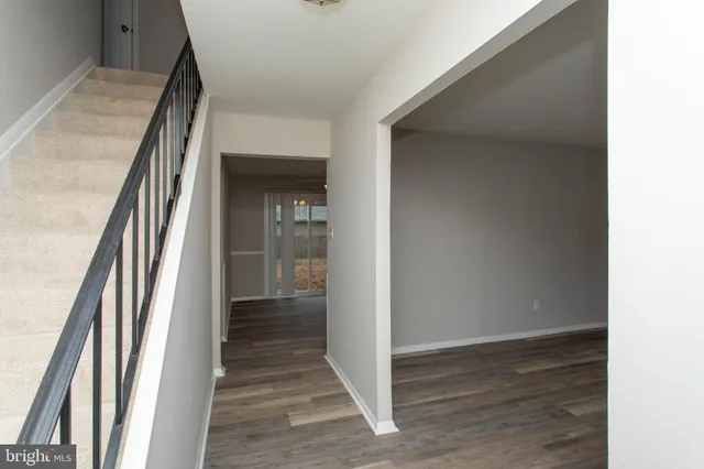 a view of a hallway with wooden floor and staircase