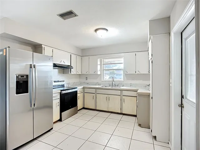 a kitchen with stainless steel appliances granite countertop a refrigerator and a sink