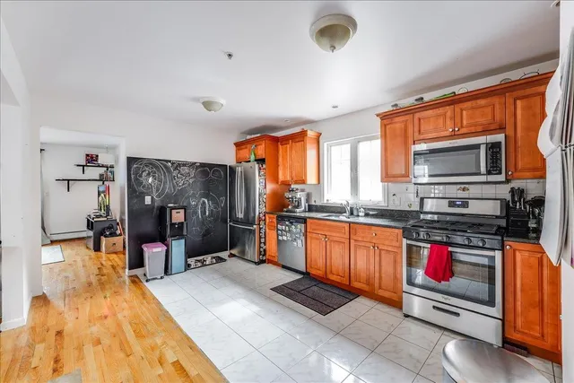 a large kitchen with stainless steel appliances granite countertop a stove and a refrigerator
