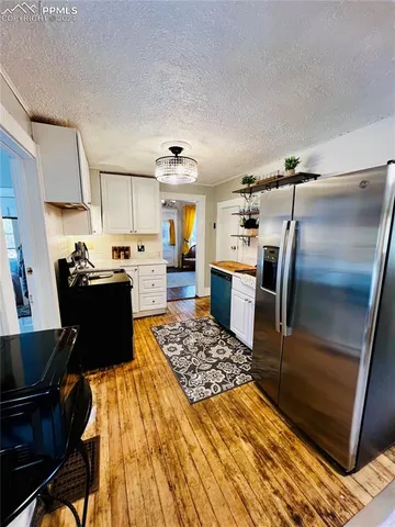 a kitchen with a refrigerator and a stove top oven